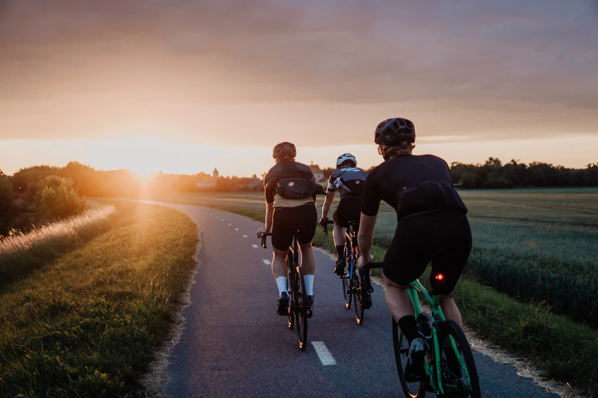 Two riders heading home along a cycle path at sunset