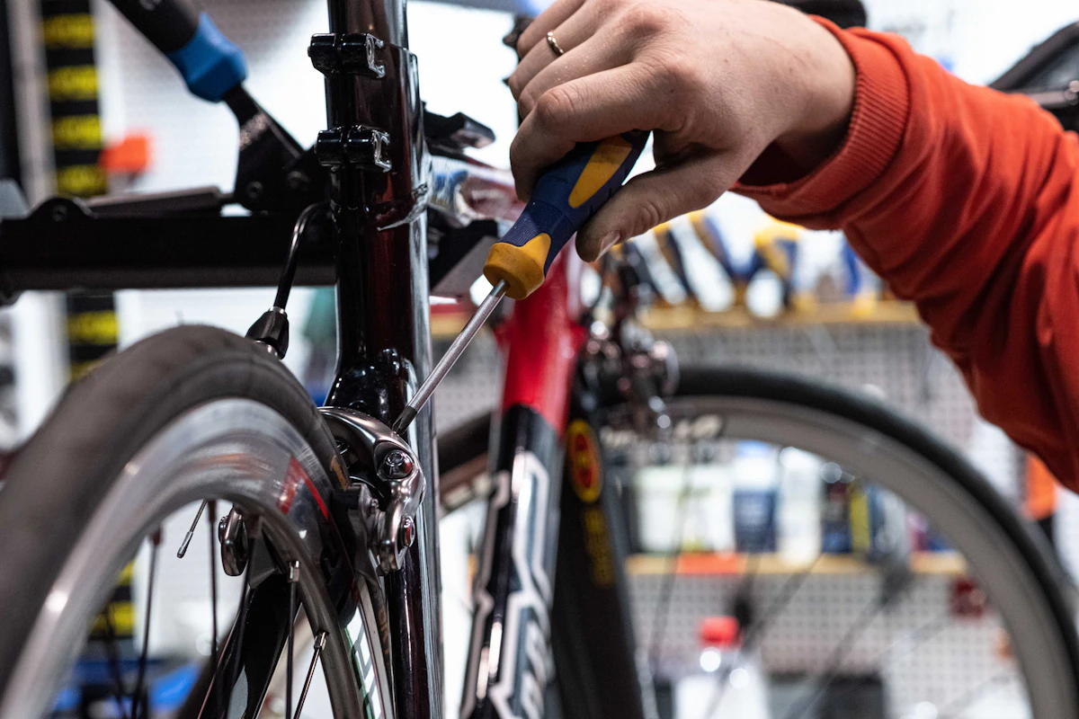 A volunteer adjusting a bike's brakes on a workstand